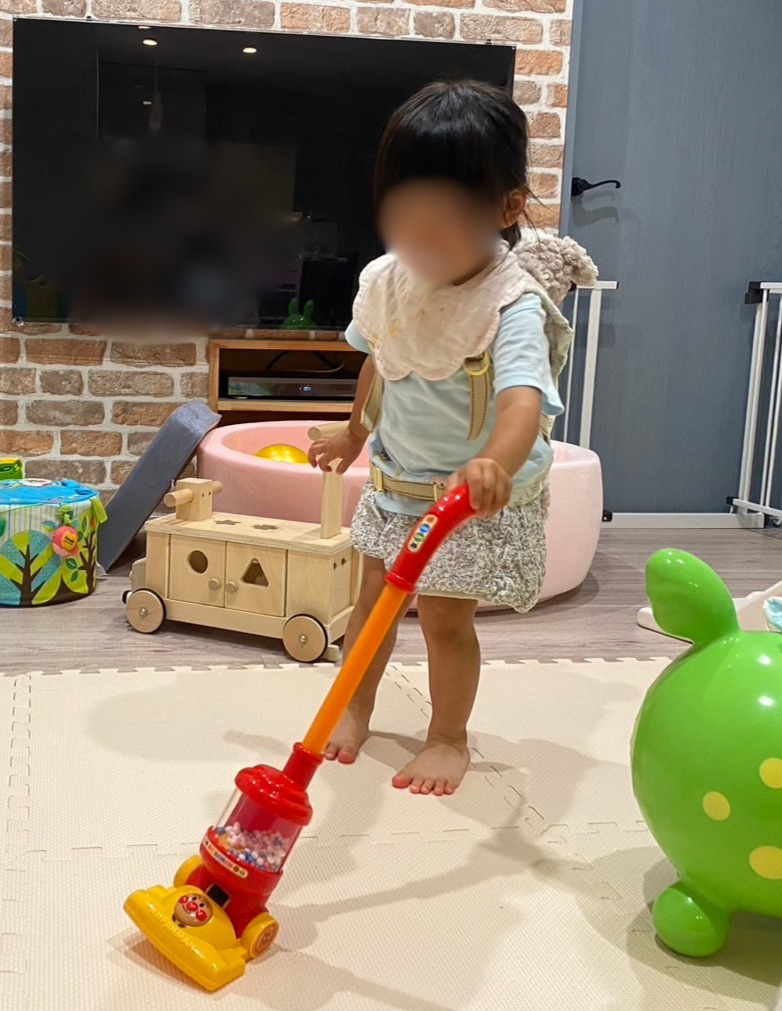 リビングで親と一緒にアンパンマン掃除機をかける子どもたち
